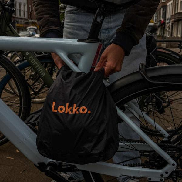 Cyclist attaching the Lokko helmet bag to their bike frame