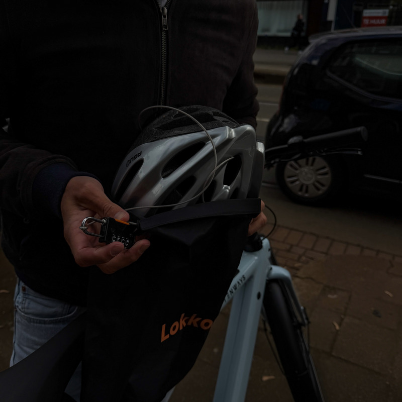 Cyclist locking a bike helmet with Lokko's keyless combination cable lock